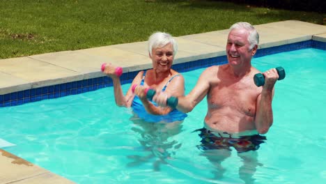 Älteres-Paar-Trainiert-Mit-Hanteln-Im-Pool