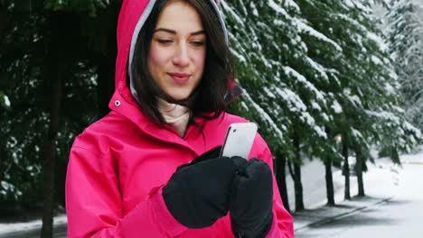 Smiling-woman-in-warm-clothing-using-mobile-phone