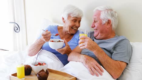 Älteres-Paar-Interagiert-Miteinander,-Während-Es-Im-Bett-Frühstückt