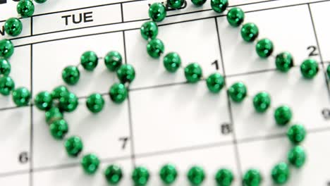 Close-up-view-of-green-accessories-on-calendar-for-st-patricks-day