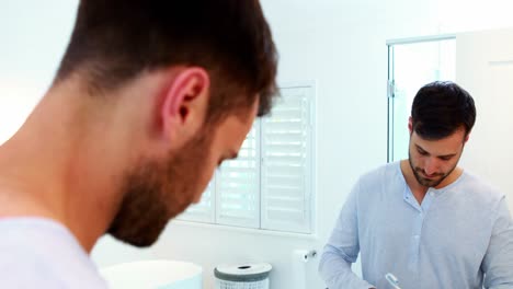 Man-brushing-his-teeth-in-bathroom