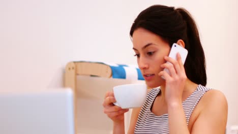 Frau-Telefoniert-Beim-Kaffeetrinken