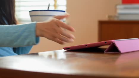 Frau-Isst-Müsli,-Während-Sie-Ein-Digitales-Tablet-Benutzt