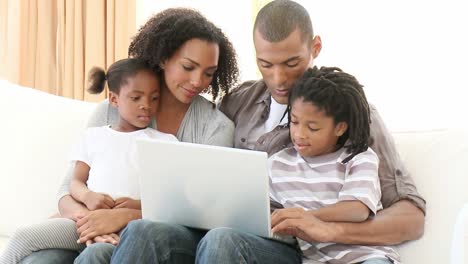Afroamerikanische-Familie-Benutzt-Einen-Laptop-Im-Wohnzimmer