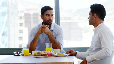 Business-colleagues-interacting-with-each-other-while-having-breakfast