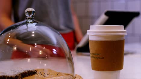 Waitress-offering-cup-of-coffee-at-counter