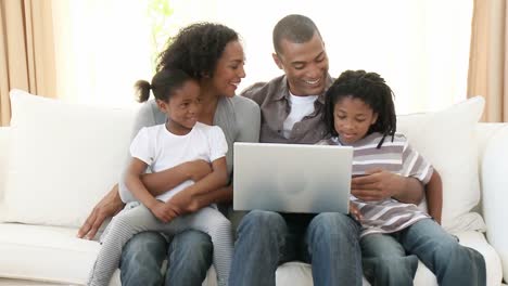 Panorama-De-Una-Familia-Afroamericana-Usando-Una-Computadora-Portátil-En-El-Sofá