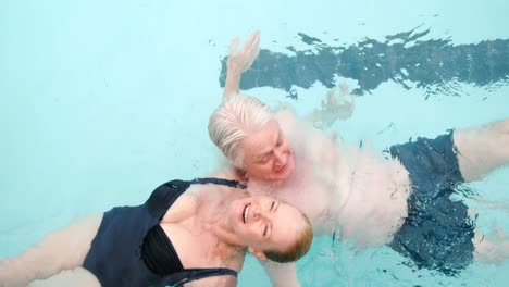 Glückliches-älteres-Paar,-Das-Im-Pool-Schwimmt