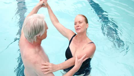 Glückliches-älteres-Paar-Tanzt-Im-Pool