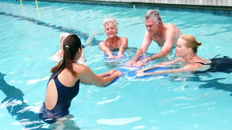 Swim-trainer-assisting-seniors-in-swimming