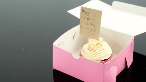 Cupcake-Mit-Glücklicher-Muttertagskarte-Vor-Schwarzem-Hintergrund