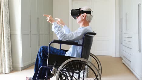 Senior-man-on-wheelchair-using-vr-headset-in-bedroom