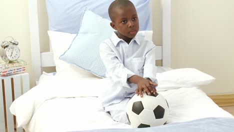Un-Niño-Afroamericano-Jugando-Con-Una-Pelota-De-Fútbol-En-Su-Habitación