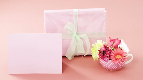 Gift-box-with-happy-mother-day-tag-and-blank-card-against-pink-background