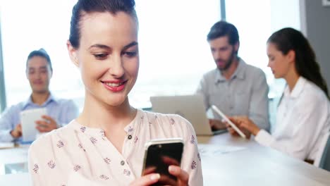 Female-business-executive-using-mobile-phone