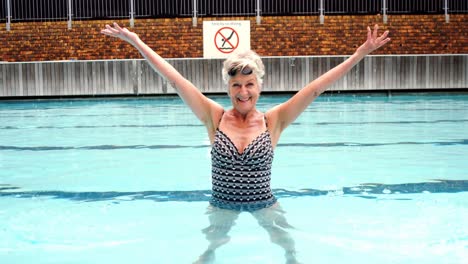 Smiling-senior-woman-enjoying-in-pool