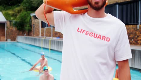 Swim-coach-standing-inflatable-floater-near-poolside