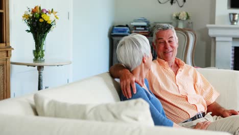 Senior-couple-interacting-each-other-on-sofa-in-living-room