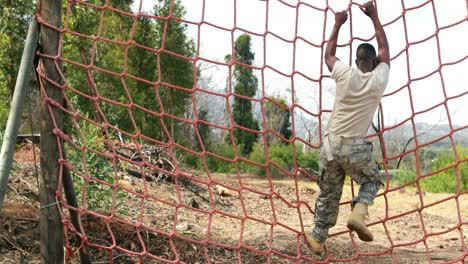 Military-soldier-climbing-rope-during-obstacle-course
