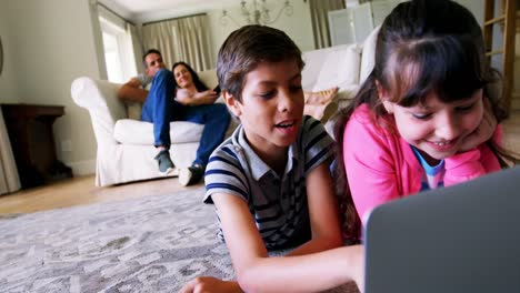 Siblings-using-laptop-in-living-room-