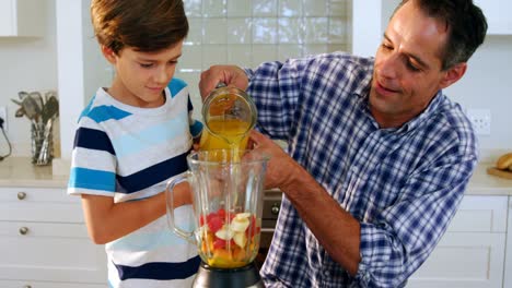 Father-and-son-preparing-smoothie-in-kitchen