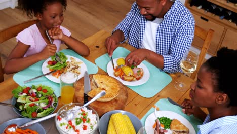 Family-having-meal-on-dinning-table-at-home