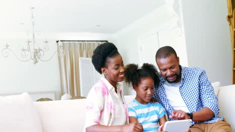 Eltern-Und-Tochter-Nutzen-Digitales-Tablet-Im-Wohnzimmer