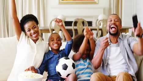 Eltern-Und-Kinder-Schauen-Sich-Im-Wohnzimmer-Ein-Fußballspiel-Im-Fernsehen-An