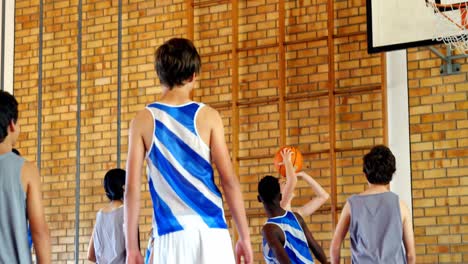 Schulkinder-Spielen-Basketball