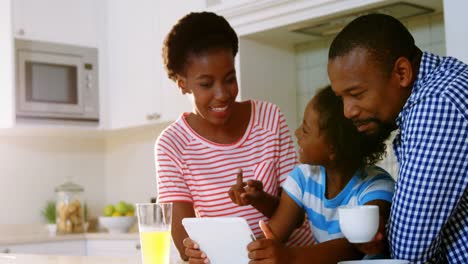 Eltern-Und-Tochter-Nutzen-Digitales-Tablet-In-Der-Küche