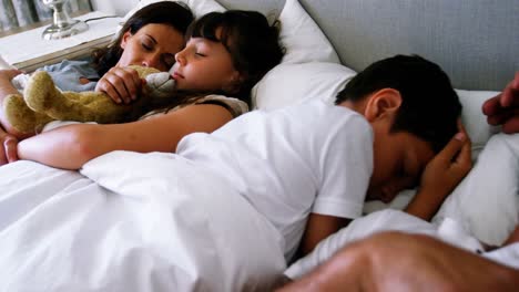 Parents-and-kids-sleeping-on-bed