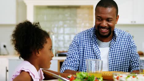 Father-and-daughter-having-meal-on-dinning-table-at-home
