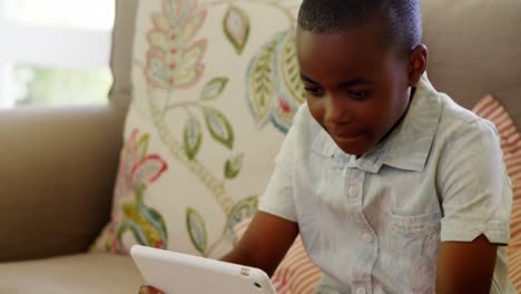 Junge-Sitzt-Auf-Dem-Sofa-Und-Benutzt-Ein-Digitales-Tablet-Im-Wohnzimmer