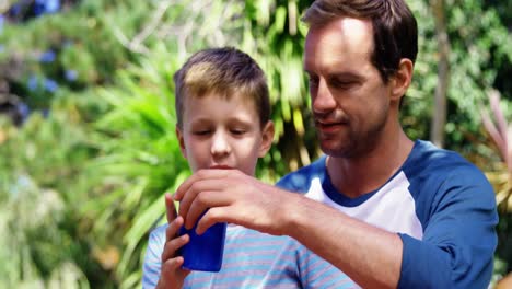Father-giving-a-glass-of-water-to-son-in-the-garden-lawn