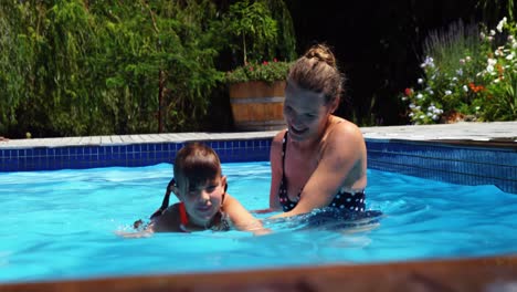 Mother-assisting-daughter-in-swimming