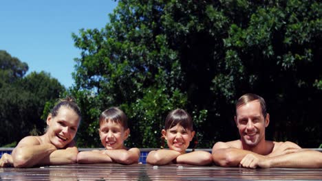 Portrait-of-family-leaning-at-poolside