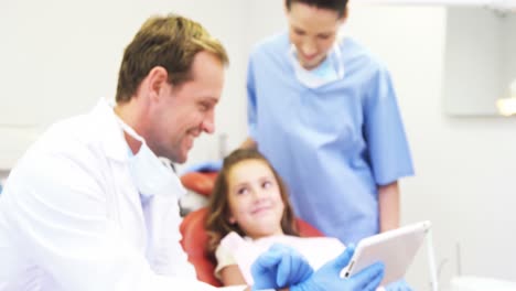 Dentists-showing-digital-tablet-to-young-patient