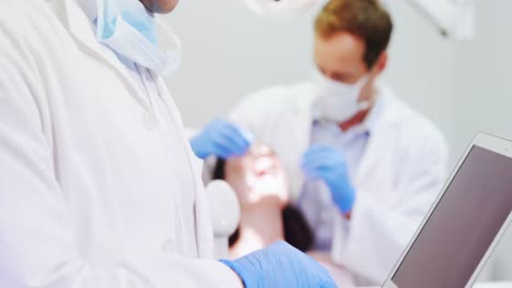 Dentista-Usando-Una-Computadora-Portátil-En-La-Clínica-Dental