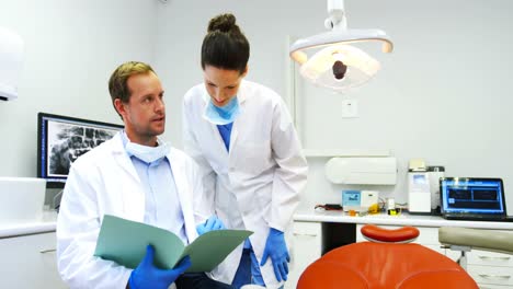Dentistas-Discutiendo-Sobre-Informe-Médico-En-La-Clínica