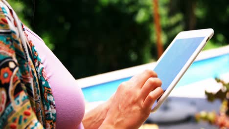 Chica-Usando-Tableta-Digital-Móvil-Cerca-De-La-Piscina