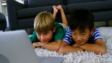 Siblings-using-laptop-in-living-room