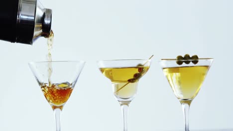 Cocktail-being-poured-into-three-glasses