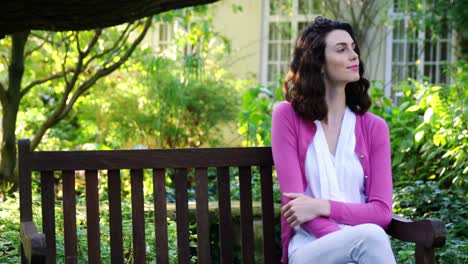 Beautiful-woman-sitting-on-bench-in-garden