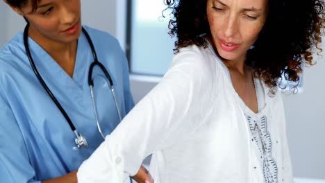Doctor-examining-pregnant-womans-back-in-ward