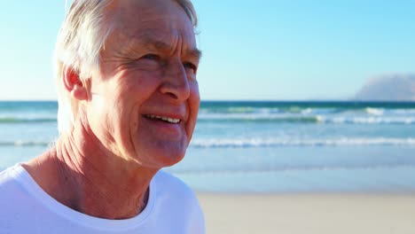 Smiling-senior-man-standing-on-beach