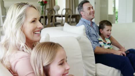 Glückliche-Familie,-Die-Gemeinsam-Im-Wohnzimmer-Fernsieht
