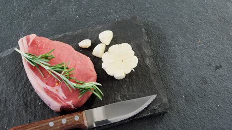 Sirloin-chop,-knife-and-garlic-on-chopping-board