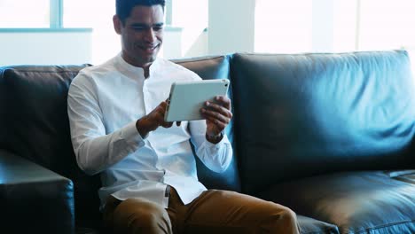 Male-executive-using-digital-tablet-on-sofa