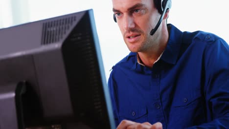 Männliche-Führungskraft-Mit-Headset,-Die-Am-Computer-Arbeitet