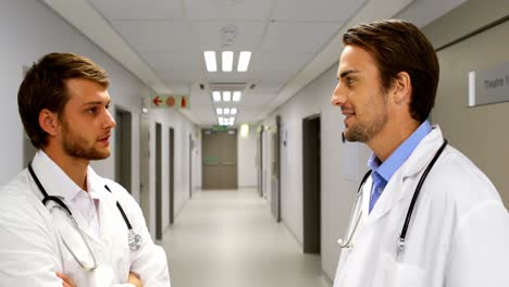 Doctors-interacting-with-each-other-in-corridor
